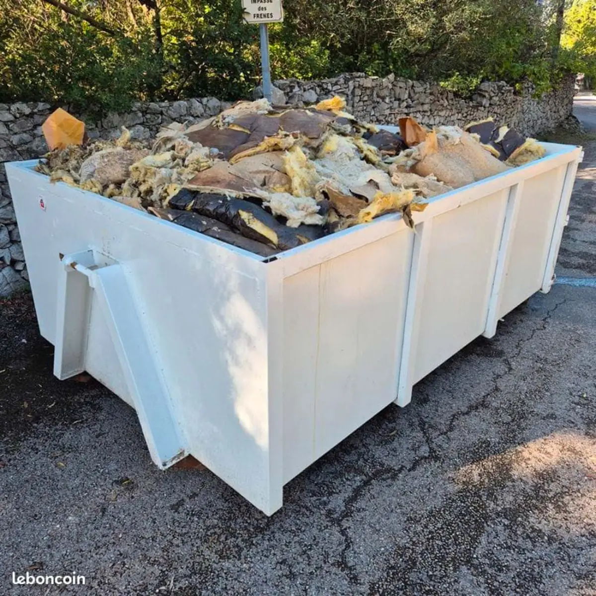 Benne de chantier BTP chargée d'isolant et de déchets mélangés
