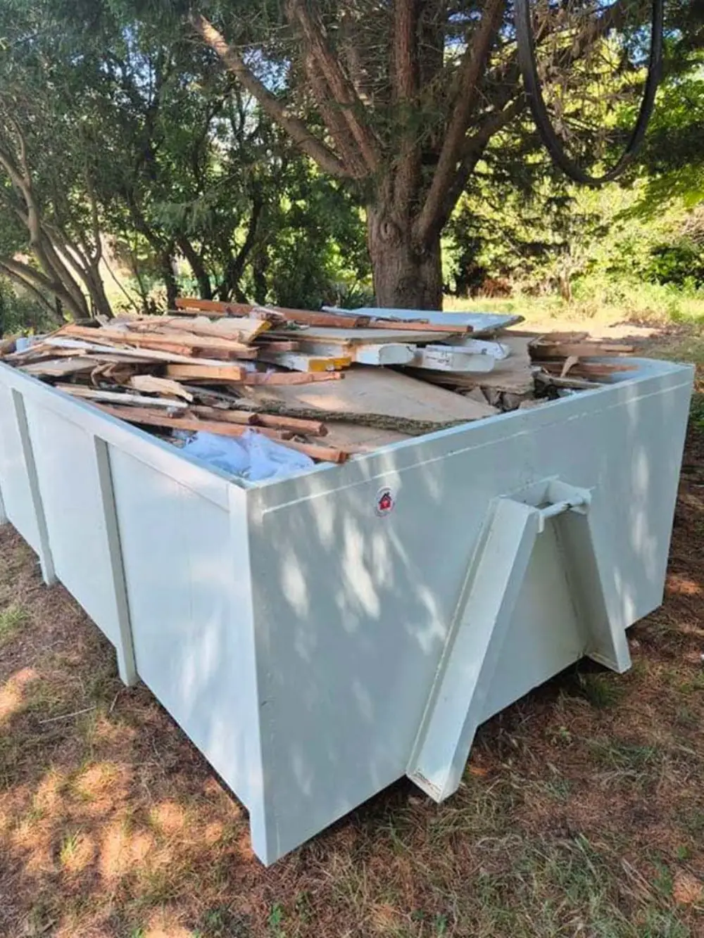 Benne chargée de bois de démolition, planches et panneaux