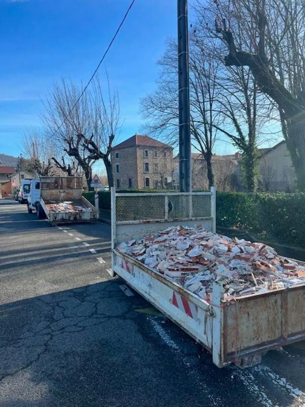 Camion-benne chargé de gravats de démolition dans une rue de la Sarthe
