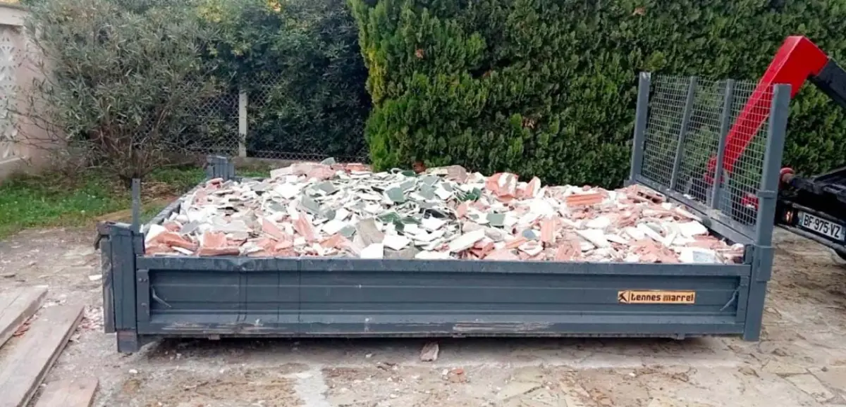 Benne basse chargée de carrelage, tuiles et gravats de démolition